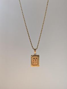 18K Gold Plated Rectangular Medallion Letter Pendant Necklace. High quality gold plating made to be waterproof, hypoallergenic and Tarnish resistant. A substantial piece you can feel in it's weight, with unique personalization, making the iconic initial style pendant more unique with the intricate details. This necklace is made to be unisex and will suit the style of any individual; perfect for everyday wear.  Features: - 316L Stainless Steel plated with 18K gold. - Hypoallergenic, waterproof an Necklace Initial Letter, Initial Letter Necklace, Custom Jewelry Box, Necklace Initial, Letter Pendant Necklace, Gold Long Necklace, Initial Pendant Necklace, Stainless Steel Plate, Letter Pendants