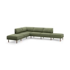 a green sectional couch sitting on top of a white floor next to a wooden frame