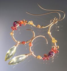 "Bright and sunny statement earrings.  Hand formed 14k gold filled curvy sculptural earrings are wire wrapped with sapphires in yellow, tangerine, pinkish orange- and purple garnet. Tipped with elongated lemon quartz (21mm). Fairly lightweight.  Length is 3 1/4\". Width is 1 1/8\". \"Nature unfolds her treasure at the first ray of sunrise.\" - Kishore Bansal About my work: My designs are my own- my visions, my history, my heart. Handcrafted from top to bottom....from ear hooks, hoops, to all the frames on which I place gemstones. The only pre-made elements used are leverbacks, chain, and lobster clasps. The rest is hand forged and fabricated by me. I use argentium sterling silver, sterling silver, 14k gold fill and karat gold. My photos speak for the extraordinary gemstones used. I don't o Sculptural Earrings, Purple Garnet, Wire Jewelry Earrings, Pinkish Orange, Orange Gem, Earrings Sapphire, Etsy Promotion, Dope Jewelry, Wire Work Jewelry