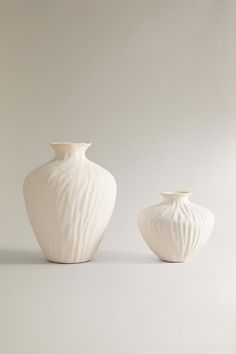 two white vases sitting next to each other