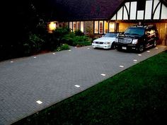 two cars parked in front of a house at night