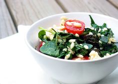 a white bowl filled with salad on top of a wooden table