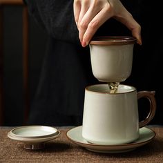 "Read please, thank you! Ruyao Cracked Glaze Tea Mug with Infuser  Dimensions mug: length 5.3\", height 4.9\", capacity 13.5oz saucer: length 5.9\" The design and making were inspired by oriental cherry. It has infuser, can be used to make kongfu tea or scented tea, all-in-one tea set. The lid can be as a coaster for infuser. Ruyao is often with a fine, irregular network of cracks. And the cracked glaze (gracked glaze) can be nourished with tea water. With using to put more tea water, the cracks can be much deeper day after day. The change of cracked glaze when you use Ruyao teaware, it can make you feel the fun of drinking kongfu tea, and taste the culture of ceramic teaware. Different teas can nourish different cracked glaze. Usually, if use to drink green tea, the cracked glaze has diff Ceramic Tea Diffuser, Tea Infuser Mug, Ceramic Tea Cup With Strainer, Tea Cup With Strainer, Handmade Pottery Coffee & Tea Cups, Ceramic Mug With Lid, Handbuilt Ceramics Coffee & Tea Cups, Puer Tea, Tea Brewer