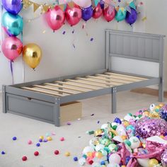 a bed with balloons and confetti on the floor