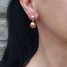 Featuring a unique design, one sphere in radiant silver and the other in warm copper, these earrings effortlessly blend sophistication with a contemporary twist. Let the contrasting metals dance together, creating a stylish and eye-catching accessory. The silver sphere is 6mm and the copper sphere is 10mm. 925 Sterling silver Copper Post back Approx. 0.9" L x 0.5" W Handmade in Taxco, Mexico Modern Sphere Earrings With Polished Finish, Modern Polished Sphere Earrings, Modern Nickel-free Rose Gold Earrings, Minimalist Silver Copper Earrings, Elegant Metallic Earrings For Gift, Silver Sphere Metal Earrings, Silver Copper Earrings For Party, Elegant Round Copper Earrings, Rose Gold Hammered Metal Earrings