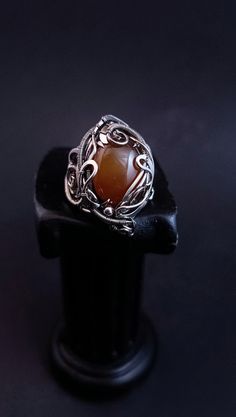 A large ring with ginger chalcedony is woven using the wire wrap technique. The ring is adjustable in size and can be adjusted to suit yours. To do this, select the size that suits you best from the menu. If you would like to purchase a set, I can offer you a bracelet https://www.etsy.com/listing/1664295369/adjustable-wire-wrapped-chalcedony?ref=listings_manager_grid ATTENTION: Please note that In reality colors of jewelry may look slightly different than colors in photos on your screen. It depends on your monitor calibration and its color rendering. HOW TO CARE: Over time, the metal may darken slightly. It depends on the degree of contamination of the surface of the jewelry. It is very easy to clean metal with cloths for jewelry. Or rub thoroughly with a toothbrush with toothpaste. After Handmade Adjustable Moonstone Ring, Handmade Adjustable Unique Moonstone Ring, Unique Handmade Adjustable Moonstone Ring, Unique Wire Wrapped Jewelry Ring, Handmade Bohemian Carnelian Ring, Bohemian Handmade Carnelian Rings, Artisan Wire Wrapped Ring Jewelry, Handmade Agate Moonstone Ring Gift, Handmade Carnelian Amber Rings