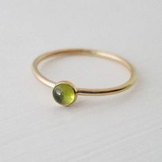 A single 4mm genuine peridot gemstone has been encased in 14k gold filled and set on a 14k gold filled stacker ring. Band measures 1.3mm thick. Stone measures 4mm. Gold Stackable Rings With Peridot Birthstone, Dainty Peridot Birthstone Ring For Gift, Dainty Peridot Birthstone Ring As Gift, Green Peridot Birthstone Ring, Dainty Style, Stackable Green Peridot Jewelry, Stackable Yellow Gold Peridot Jewelry, Green Peridot Stackable Jewelry, Dainty Green 14k Gold Stackable Rings, Yellow Gold Stackable Rings With Peridot