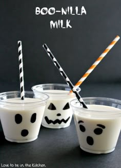 three cups with halloween milk in them and two straws sticking out of the top