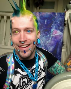 a man with colorful hair and piercings on his head