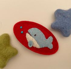 two felt toys are laying on the table next to each other and one has a fish in it