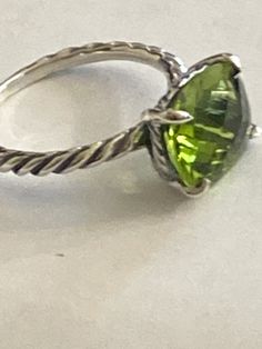 Previously USED  David Yurman Cushion Ring size 7 100% AUTHENTIC  COLOR STONE RING COLLECTION  Ring has been cleaned  Estimated Retail $395-$695 12mmx10mm  Faceted Center Stone  PERIDOT  -DY Checkerboard Faceting  925 Sterling Silver    usps Signature+ Insurance   Item must be packed in original condition and packed with original contents Formal Green Stackable Rings, Formal Lime Green Peridot Jewelry, Classic Peridot Solitaire Jewelry, Classic Solitaire Peridot Jewelry, Luxury Oval Peridot Rings, Luxury Peridot Rings With Accent Stones, Luxury Peridot Jewelry With Accent Stones, Luxury Green Rings With Vs Clarity, Green Stackable Rings For Formal Occasions In May