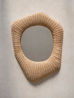 a wicker mirror hanging on the wall