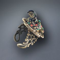 Our snake ring is in the form of a royal serpent with crystal eyes, a neck band of tiny crystal and a body detailed in enamel. Three dimensional, he rests gracefully upon an adjustable, comfortable ring band that fits sizes 6-9. Choice of bronze or silver finish. Shakespeare wrote "Be the innocent flower...be the serpent under it!" Produced in our Los Angeles studio. The snake has been a powerful symbol from the beginning of human history. The serpent goddess Wadjet was an early Egyptian deity. In the Garden of Eden, it is the serpent who creates the drama. The snake's dual symbolism of good and evil has been expressed through all cultures. The very first engagement ring ever presented was to Queen Victoria from Prince Albert. It was a snake, signifying eternal love and wisdom and the betr Serpent Goddess, Snake Rings, Serpent Snake, Egyptian Deity, Crystal Eyes, The Garden Of Eden, Crystal Eye, The Serpent, Egyptian Goddess