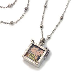 "A miniature photo box holds a retro comic image between two glass panes. You can easily remove them and replace with your own photos or images. Burnished silver finish. 29\" metal beaded chain. Locket is 0.75\" L x 0.75\" W. Arrives ready to gift. Made in our Los Angeles studio. Contact us for bulk pricing and wholesale information." Chain Locket, Tech Jewelry, Glass Panes, Box Necklace, Locket Pendant Necklace, Photo Box, Retro Comic, Friend Necklaces, Photo Locket