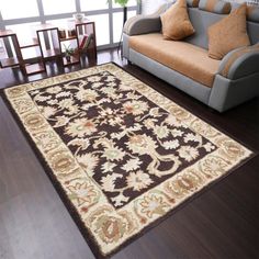 a living room with a couch, chair and rug on the floor in front of a window