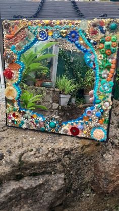 a mirror sitting on top of a rock