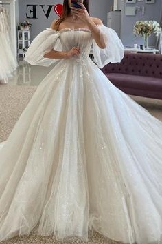 a woman taking a selfie wearing a wedding dress with long sleeves and sequins