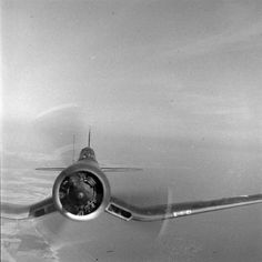 an old airplane flying in the sky with its landing gear down and it's engine out