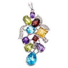 This cheerful pendant is a grape cluster motif, set with multiple shaped and sized semi precious stones, including London blue color blue topaz (app. 1.59 TCW), purple amethysts (app. 0.61 TCW), chartreuse green color peridot (app. 0.62 TCW), golden yellow citrine (app. 0.40 CTS) and burgundy garnets (app. 0.56 TCW). The gemstone "grapes" are accented by round diamond set "leaves", approximately 0.04 TCW. The pendant is topped with a solid style bale. Marks: 750 Dimensions: 1 1/2" long including bale x 11/16" wide Luxury Round Multi-stone Jewelry, Elegant Multicolor Pendant Gemstones, Elegant Multicolor Gemstone Pendant, Multi-stone Pendant Gemstones For Jewelry Making, Multicolor Gemstone Pendant With Accents, Diamond Necklace Indian, Art Deco Pendant Necklace, Round Diamond Setting, Chartreuse Green