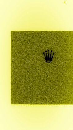 a green square with a black crown on the center and yellow background above it is an image of grass that has been cut into smaller squares