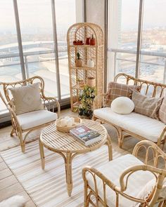 a living room with wicker furniture and large windows looking out on the cityscape