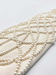 The perfect accessory for any upcoming events, the NANDANIE Ivory Pearl necktie adds elegance and whimsy to your event looks. Wrap and snap like all of our styles, there is nothing like out there to elevate your outfits for all your bridal events. Style with a tailored white suit for a structured and unique look. Layer with pearl jewelry for added drama. Size 1: 14.5-16.5” neckband Size 2: 15.5-17.5” neckband Elegant Beaded Bridal Accessories For Party, Elegant Fitted Bridal Accessories For Party, Formal Bridal Accessories In Pearl White, Elegant Beaded Bridal Accessories For Evening, Classic White Bridal Accessories For Formal Occasion, Elegant White Bridal Accessories For Evening, Elegant Bridal Accessories With Pearl Embroidery For Ceremony, Elegant Pearl Bridal Accessories For Formal Occasions, White Adjustable Bridal Accessories For Formal Occasions