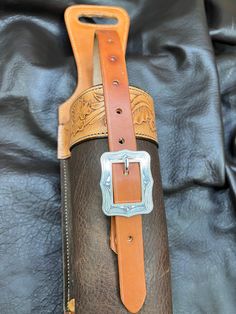 a brown and tan leather case sitting on top of a black cloth