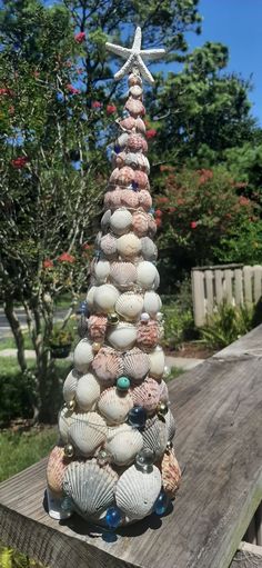 a christmas tree made out of seashells on a wooden deck