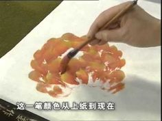 someone is painting oranges on paper with a brush