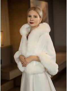 a woman in a white dress and fur coat