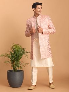 Vastramay Men's Pink Mirror Indo Western Sherwani with Kurta Pyjama Set Look impeccably stylish in this pink mirror work Sherwani set. Featuring a trendy Indo-Western design, the Sherwani boasts intricate mirror work and a mandarin collar, while the Kurta and Pyjama complement perfectly. Key Features Aqua blue mirror work design on Sherwani Mandarin collar, full sleeves on Sherwani, Kurta & Pyjama Cream colored Kurta and Pyjama Elasticated waistband with button closure on Pyjama Specifications S Pink Kurta For Eid Reception, Traditional Long Sleeve Pink Bandhgala, Traditional Pink Long Sleeve Bandhgala, Pink Kurta For Reception And Transitional Season, Pink Fitted Nehru Jacket, Designer Gota Work Kurta For Eid, Pink Nehru Jacket With Resham Embroidery, Designer Pink Kurta With Resham Embroidery, Long Sleeve Pink Kurta With Gota Work