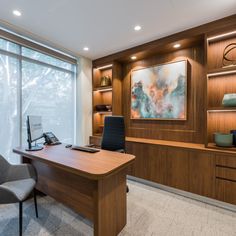 an office with a desk, chair and large window