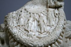 a white sculpture with people and animals on it