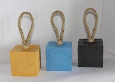 three different colored blocks with rope on them