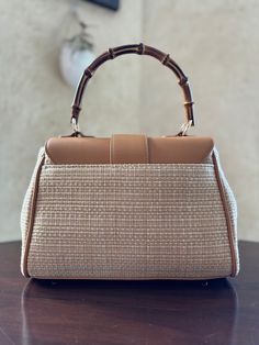 Upgrade your spring & summer game with our Contrast Straw Handbag. Crafted with structured straw and a chic bamboo handle, this handbag is equal parts classic and stylish. This bag is perfect for any occasion! DETAILS Beautifully structured straw-style handbag with a bamboo handle. This handbag has a contrasting flip open lid and accents in tan. Includes a tan crossbody strap for added flexibility. Magnetic closure and snaps on the side to easily expand its carrying capacity (even snapped, it's Classic Summer Bags With Leather Handles, Elegant Straw Tote Bag With Detachable Strap, Chic Top Handle Straw Bag, Chic Satchel Straw Bag With Detachable Strap, Classic Bags With Leather Handles For Summer, Chic Straw Bag With Detachable Handle, Chic Straw Top Handle Bag With Detachable Handle, Chic Top Handle Straw Bag With Detachable Handle, Chic Straw Satchel Bag With Detachable Strap