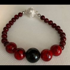 Red Beads With One Black Onyx Bead With Sterling Silver Swarovski Magnet Closure. 8 Inch Elegant Red Round Bead Bracelets, Red Adjustable Beaded Bracelets For Formal Occasion, Red Adjustable Beaded Bracelets For Formal Wear, Elegant Red Round Beaded Bracelets, Handmade Formal Beaded Bracelets, Elegant Red Gemstone Beads, Formal Handmade Beaded Bracelets, Elegant Red Beaded Necklace With Black Beads, Elegant Red Beaded Bracelets