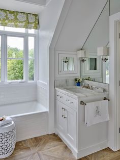 a white bathroom with two sinks and a window