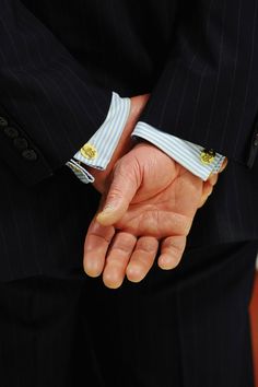 a man in a suit holding his hand out