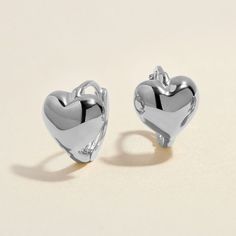 Heart goes padam padam in these hoops. Bae's chubby heart motif, set on a 8mm huggie, are the sweetest addition to your ear stack. Minimal, sophisticated and chic, these shapely hoops will have hearts skipping beats. Created for you in the finest 14 karat white gold, you'll want to wear these earrings always and never take them off, even when working out or in the shower. Elegant White Gold Huggie Heart Earrings, Dainty Tarnish-resistant Huggie Heart Earrings, Hypoallergenic Heart-shaped White Gold Earrings, Elegant Heart-shaped Sterling Silver Huggie Earrings, Heart-shaped Sterling Silver Huggie Earrings, Padam Padam, Earrings White Gold, Heart Motif, Ear Stack