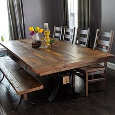 a dining room table with two benches in front of it and flowers on the table