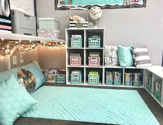 a room with several shelves filled with books and decorative items on the floor, along with a blue rug