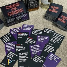 some cards that are sitting on the ground next to liquor bottles and a bottle opener