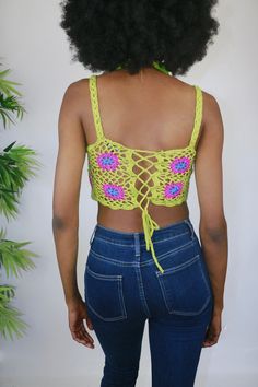 This crochet top is an ultra breezy and edgy style option. She is dyno-mite with a halter swim top or bralette. But for my free spirited sister, you can wear her as is to a festival or beach party. She's a retro green and with pink crochet flowers. She features a corset style back so that you can cater her to your own custom fit! Style Tip: Use as a swim stop cover or style with ribbed denim shorts for a easy casual look Made of Acrylic Green Crop Top For Vacation, Green Crochet Beachwear Top For Spring, Green Crochet Top For Beachwear In Spring, Green Crochet Top For Spring Beachwear, Trendy Stretch Crochet Top For Beach, Green Halter Top For Summer Beach Party, Bohemian Cropped Tank Top For Vacation, Green Crochet Beachwear Top For Summer, Hippie Halter Neck Crochet Top For Summer