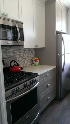 a kitchen with stainless steel appliances and white cabinets