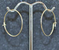 "These goldfill 7/8\" (22 mm) hoops are forged from 14/20 goldfill. They are made by winding 1/2 hard 20 gauge (.812 mm) round goldfill wire on a mandrel. They are then given the catch loop, filed and polished. This style of hoop is often referred to as a \"sleeper\" hoop because they are small and will lay somewhat flatter against the head than a post earring will. These hoops are each 7/8\" (22 mm). Please allow for some handmade variance. These are light and comfortable to wear. I sell them b Internally Threaded Yellow Gold Hoop Earrings, Adjustable Small Hoop Earrings Nickel Free, Handmade Small Hoop Gold Nose Rings, Handmade Gold Small Hoop Nose Rings, Nickel-free Hoop Septum Ring, Nickel Free Minimalist Hoop Septum Ring, Minimalist Nickel-free Hoop Septum Ring, Small Hoop Brass Cartilage Earrings, Nickel-free Hoop Septum Ring For Everyday