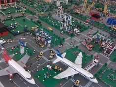 an aerial view of a model airport with airplanes and other vehicles on the ground in front of buildings