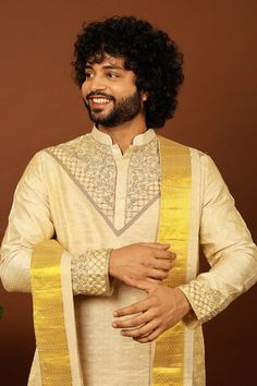 Gold pattu kurta featuring zari and cutdana hand embroidery on the neckline and sleeve hem. Paired with a dhoti pant and a kanduva. - Aza Fashions Ceremonial Cotton Silk Bandhgala For Festivals, Ceremonial Cotton Silk Traditional Wear With Resham Embroidery, Transitional Designer Kurta With Cutdana, Ceremonial Cotton Silk Bandhgala With Zari Work, Zari Work Cotton Silk Bandhgala For Festivals, Traditional Cotton Silk Bandhgala For Ceremonial Occasions, Cotton Silk Bandhgala With Zari Work For Festivals, Cotton Silk Bandhgala With Pallu For Transitional Season, Designer Tussar Silk Gold Kurta