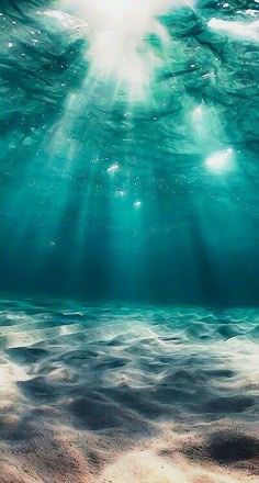 an underwater view of the ocean with sunbeams