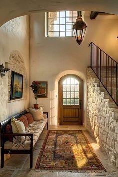 an entry way with a couch and rug on the floor in front of a door