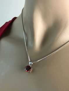 "Sterling Silver Garnet Necklace, Garnet Cubic Zirconia Pendant Necklace NECKLACE FEATURES: Metal: All components are made from solid .925 Sterling Silver Model is wearing 16\" in length solid .925 Sterling Silver Chain Length available: 16\", 18\" or 20\" Stone: Garnet CZ THE Garnet CZ pendant measures 8mm in height Your Garnet Necklace will arrive in a gift box, beautifully wrapped and ready for gifting Please send me a convo if you have any questions before placing your order. Please also vie Elegant Red Jewelry For Birthday, Red Round Stone Necklaces For Anniversary, Red Round Birthstone Necklace For Anniversary, Classic Birthday Jewelry With Prong Setting, Red Necklace With Prong Setting As Gift, Red Birthstone Necklace For Birthday, Red Round Cut Necklace For Anniversary, Classic Red Birthstone Necklace As Gift, Classic Red Birthstone Necklace For Gift